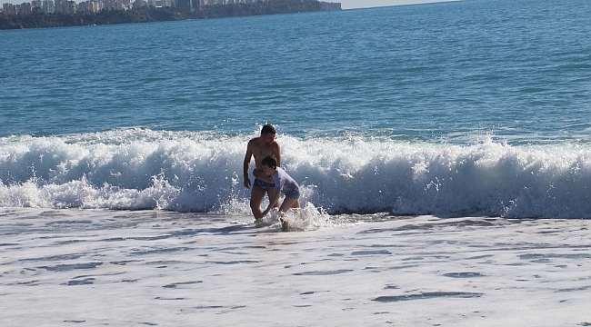 Antalya'da karla kaplı dağların gölgesinde turistlerin deniz keyfi
