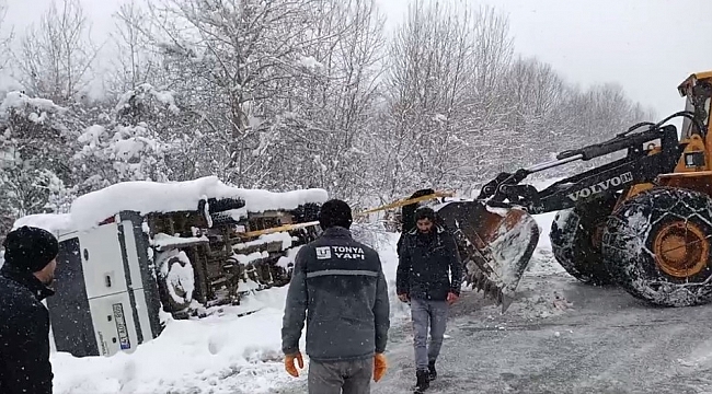 Karlı yolda yan yatan minibüsü iş makinesi ile kurtardılar