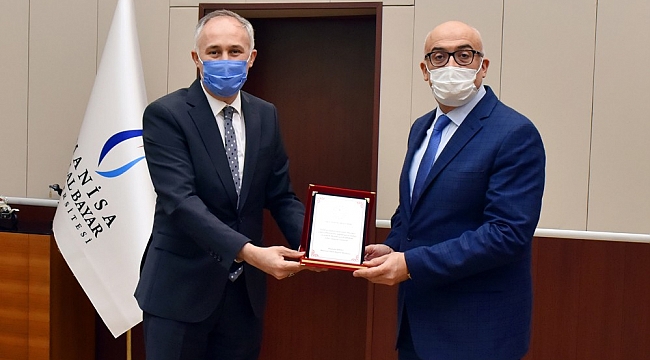 Rektör Ataç'a uzaktan eğitime katkılarından dolayı plaket