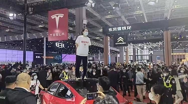 Çinli kadından Tesla protestosu: Fuarda aracın üzerine çıkıp bağırdı