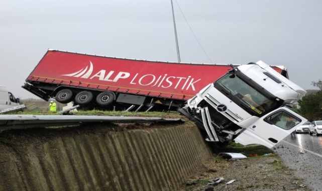 Büyükçekmece'de bariyerleri yıkıp iki yol arasında asılı kalan tırın sürücüsü yaralandı