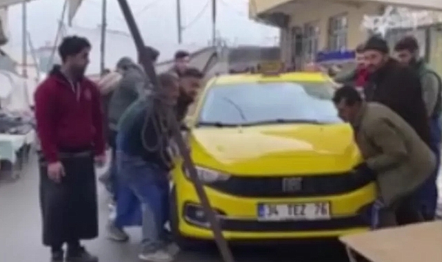 Pazar alanına park edilen taksiyi elleriyle taşıdılar