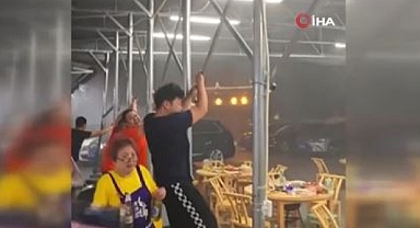 Çin'de şiddetli rüzgar tenteye tutunan insanları uçurdu