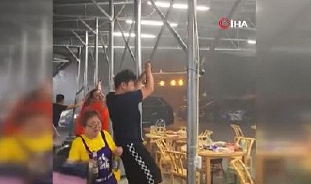 Çin'de şiddetli rüzgar tenteye tutunan insanları uçurdu