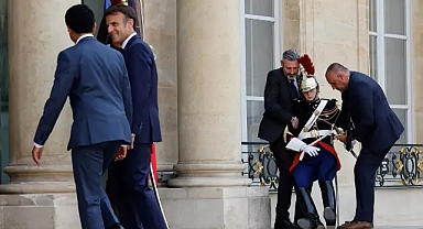 Muhafız sıcaktan baygınlık geçirdi, Macron poz vermeye devam etti