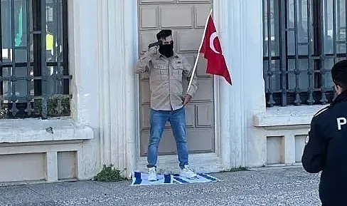 İzmir'de bir kişi kafasına silah dayayıp İsrail bayrağının üzerine basarak eylem yapıyor