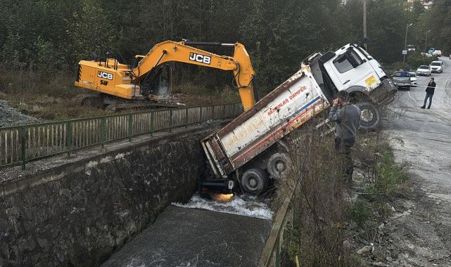 Kontrolden çıkan kamyon, altına aldığı otomobille dereye düştü