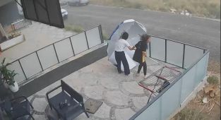 Şiddetli rüzgarın şemsiyeyle imtihanı kamerada